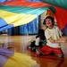Dicken Elementary schooler Logan Seiler, 7, smiles as he hangs on to a corner of a colorful parachute while playing Intramural Sports Building during the 14th Annual Kids' Fair at University of Michigan on Friday. Melanie Maxwell I AnnArbor.com
